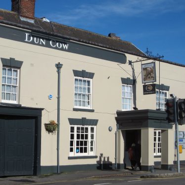 Front of the Dun Cow pub at Dunchurch. 2-storey cream painted Georgian building with square porch and pub sign above | Anne Langley
