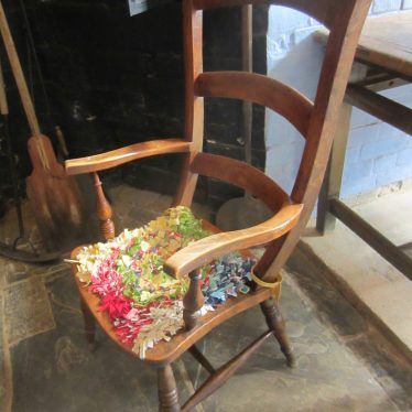 Colourful rag cushion on a wooden chair | Anne Langley