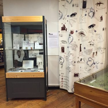 Glass case and hanging curtain decorated with maps etc | Photo courtesy of Olivia Hewkin