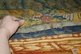 Hidden Secrets of the Sheldon Tapestry - a fragment of the original border, showing a bunch of grapes and architectural detail. | Photo courtesy of Warwickshire Museum