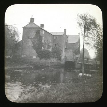 River emerging from 3-storey L-shaped brick building with extension | Courtesy of Warwickshire CC, Rugby Library Local Studies Collection; WCRO PH827/5/26; photographer Rev. E. Dew