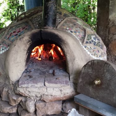 Earth oven with a fire burning inside, ready for pizza! | Kristie Naimo