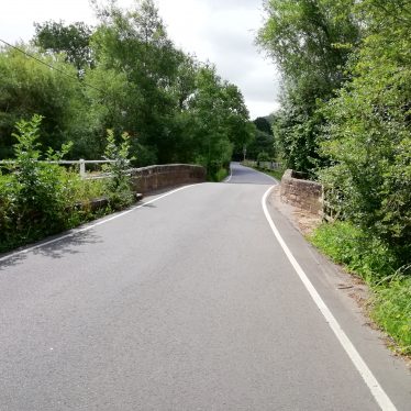 road in foreground over Offchurch bridge; trees on either side | Image courtesy of Gary Stocker June 2020