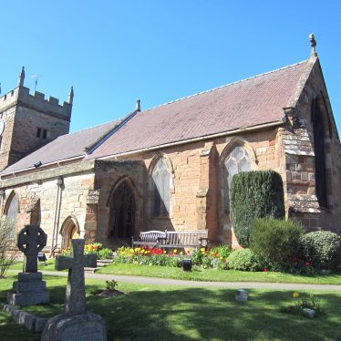 Red sandstone church, tiled, with tower with blue clockface on from the churchyard | Image courtesy of Anne Langley