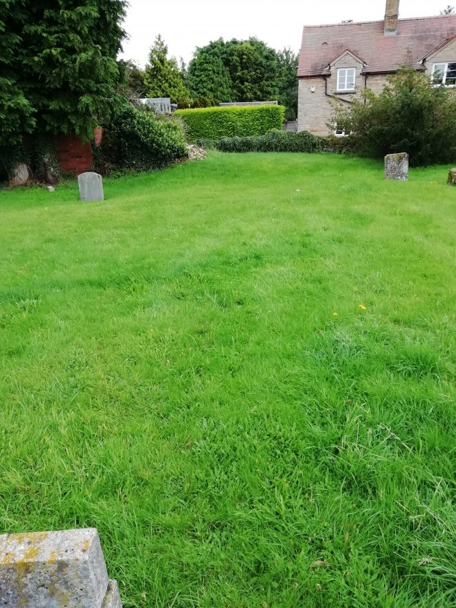 Grassy graveyard with house in background | Image courtesy of Gary Stocker