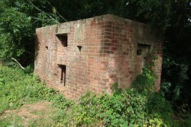 World War Two red brick pillbox, with overhanging trees