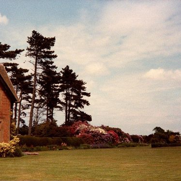Redbrick house in left hand corner of photo with trees to the right and lawn in front | Joanna Illingworth's family album