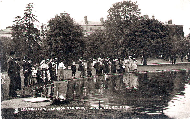 Jephson Gardens, Leamington Spa.   A crowd of people feeding the goldfish.  1900s |  IMAGE LOCATION: (Warwickshire County Record Office)