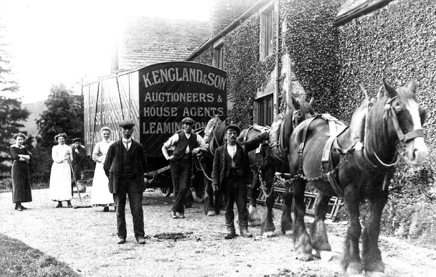 K England & Son, Auctioneers and House Agents covered wagon and horses. Group of workers standing alongside.  1900s |  IMAGE LOCATION: (Warwickshire County Record Office)