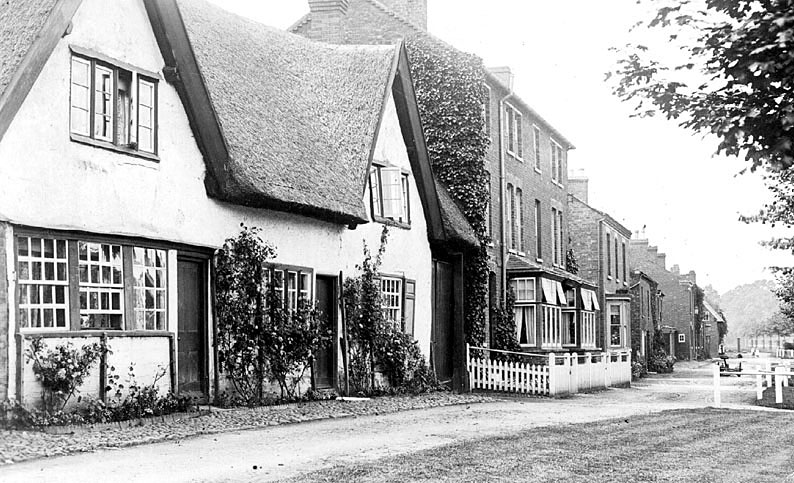 Row of houses on the street with thatched cottages, Hillmorton.  1900s |  IMAGE LOCATION: (Warwickshire County Record Office)