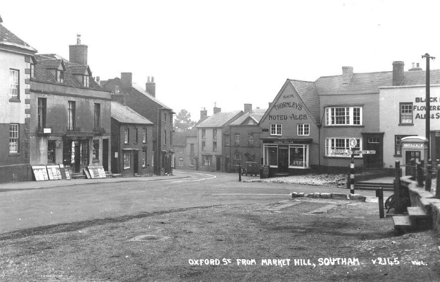 Market Hill looking towards Oxford Street; shows the Black Dog Inn and a newsagents, telephone box by the side of the road.  1930s |  IMAGE LOCATION: (Warwickshire County Record Office)