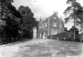 The Lodge at Hatton Asylum with a nurse standing at the gate.  1900s |  IMAGE LOCATION: (Warwickshire County Record Office)