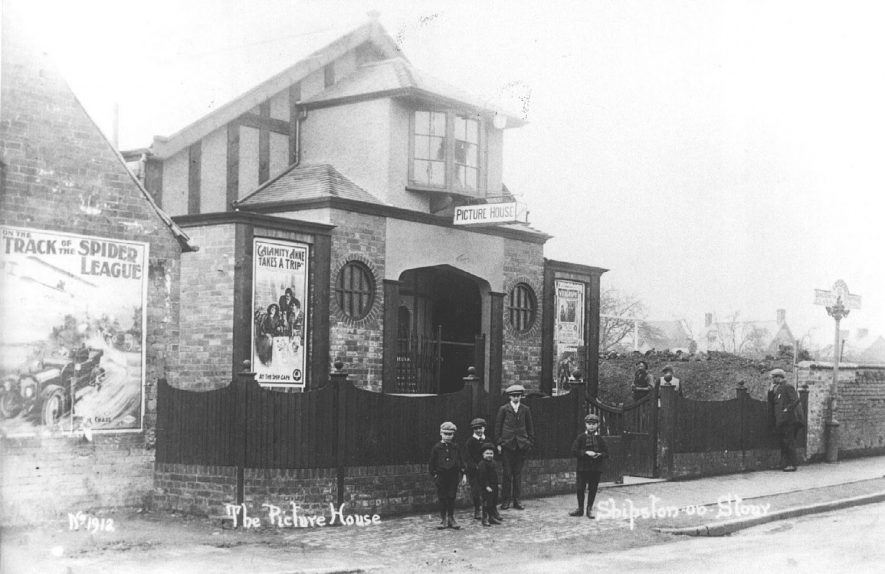 The Picture House, Shipston on Stour. Men and boys in street. Posters showing current film.  1900s |  IMAGE LOCATION: (Warwickshire County Record Office)