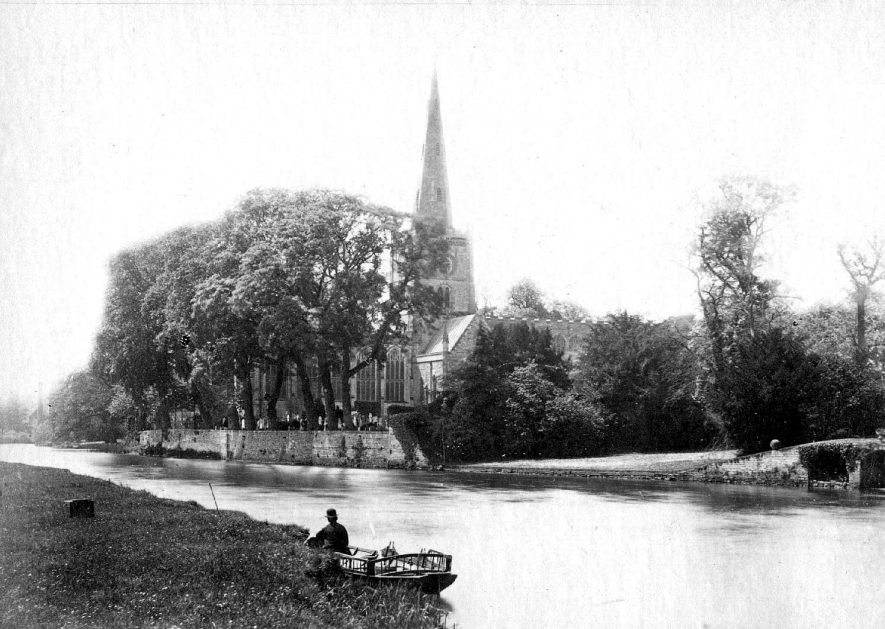 Holy Trinity Church, Old Stratford, seen across the River Avon. Man in rowing boat near bank, Stratford upon Avon.  1900s |  IMAGE LOCATION: (Warwickshire County Record Office)