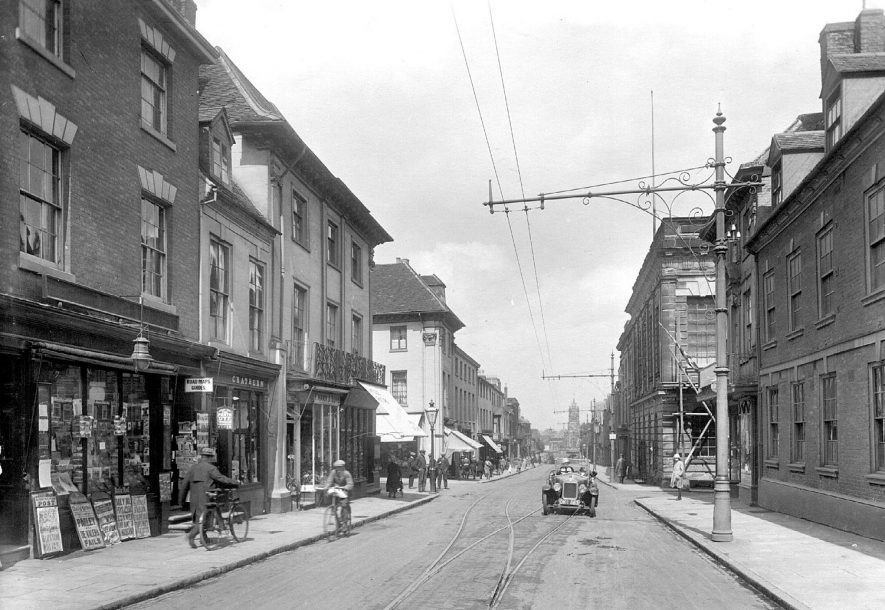 High Street, Warwick showing shops, tramwires and a car.  1922 |  IMAGE LOCATION: (Warwickshire County Record Office)