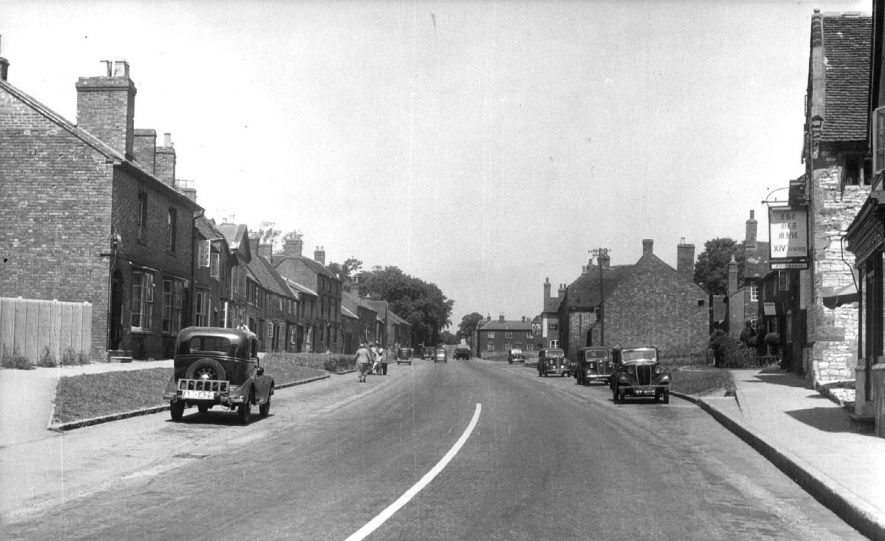 Coventry Street, Southam showing the Old Mint on the left. Motorcars parked along the street.  1950s |  IMAGE LOCATION: (Warwickshire County Record Office)