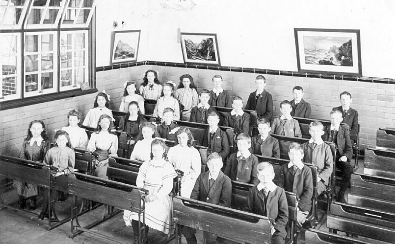 Boy and girl pupils at desks in class room, Nuneaton.  1900s |  IMAGE LOCATION: (Warwickshire County Record Office)