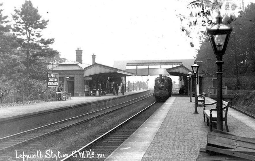 Picture of the railway station at Lapworth, with train approaching the platform and showing the passenger footbridge.  Circa 1924 |  IMAGE LOCATION: (Warwickshire County Record Office)