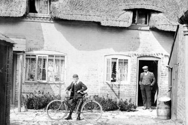 Moreton Morrell.  Man and boy with bicycle