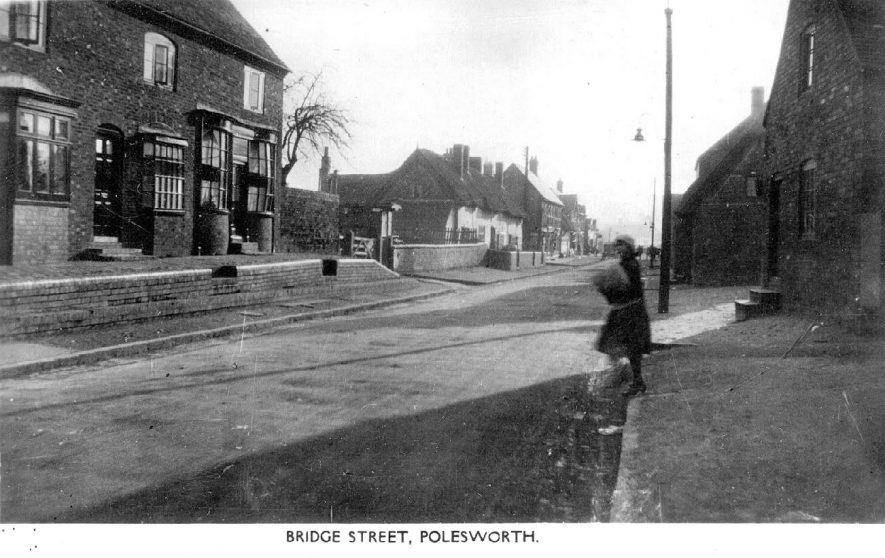 Street scene in Polesworth showing the elevated pavement.  The building on the left has an unusual double bow fronted window.  1920s |  IMAGE LOCATION: (Warwickshire County Record Office)
