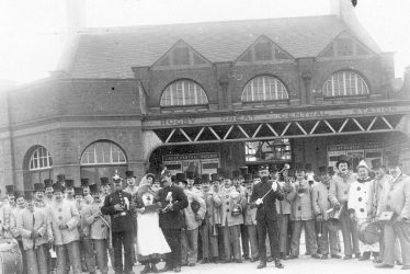 Rugby.  Comic Band outside the Great Central Railway Station