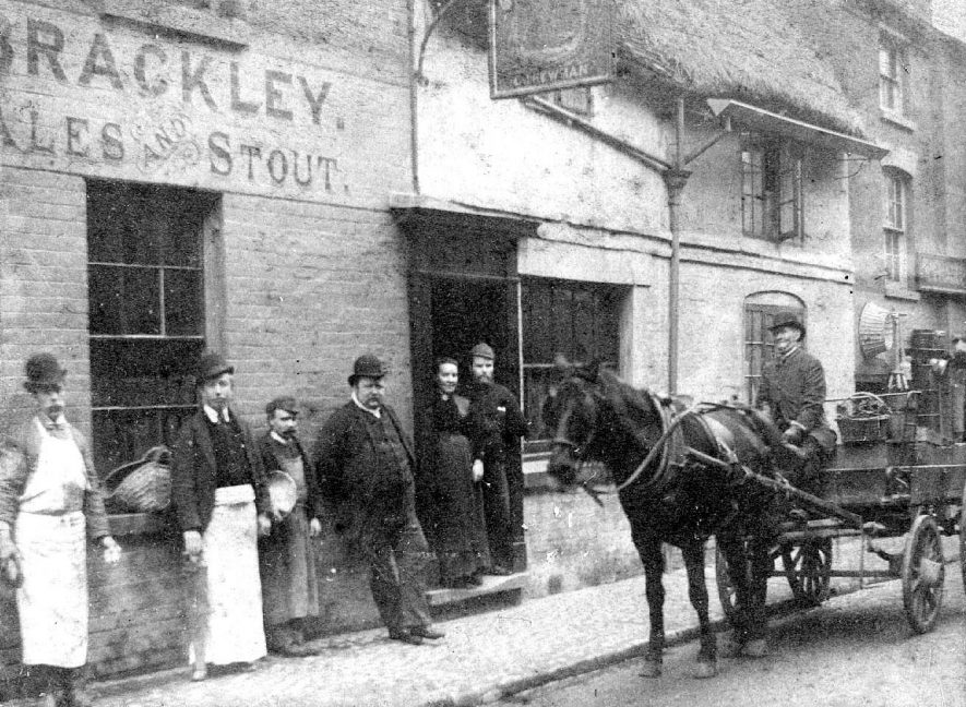 The Black Swan Public House, Rugby. Staff standing in street outside front door.  Proprietor Chas. Newman.   W. Naseby, market gardener, with horse and cart.  Washing dolly and washing basket on cart.  1894 |  IMAGE LOCATION: (Warwickshire County Record Office) PEOPLE IN PHOTO: Newman, Chas, Newman as a surname, Naseby, W, Naseby as a surname