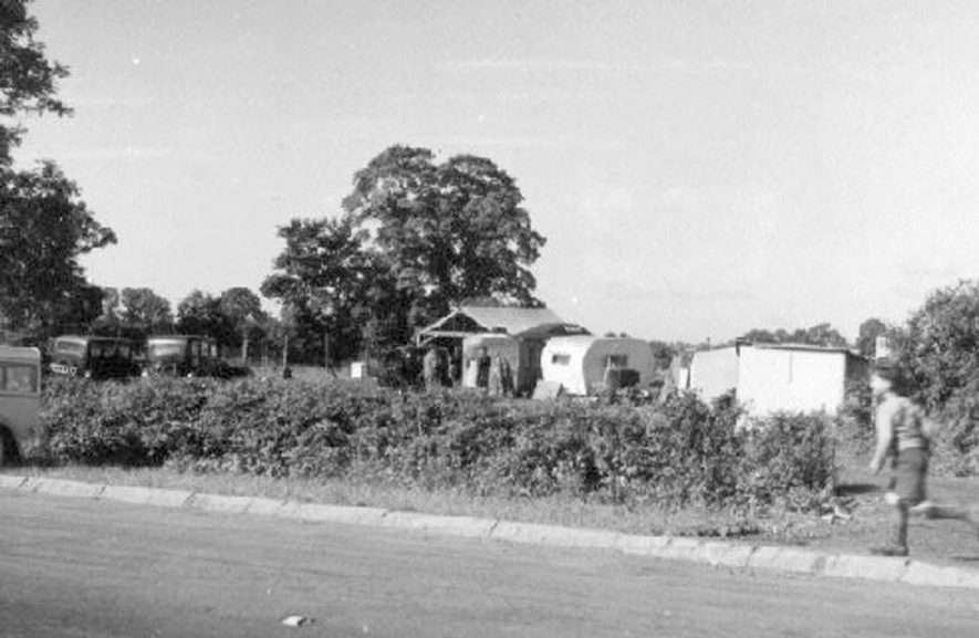 A motor mart, Southam Road, Long Itchington; showing cars, a caravan and a boy running along the road.  1950s |  IMAGE LOCATION: (Warwickshire County Record Office)