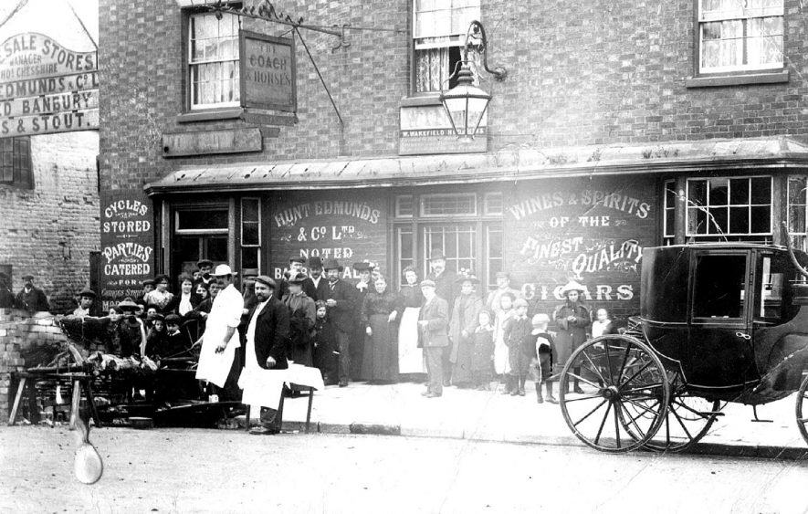 A pig roast outside the Coach & Horses in Henley Street, Stratford upon Avon.  1900s |  IMAGE LOCATION: (Warwickshire County Record Office)