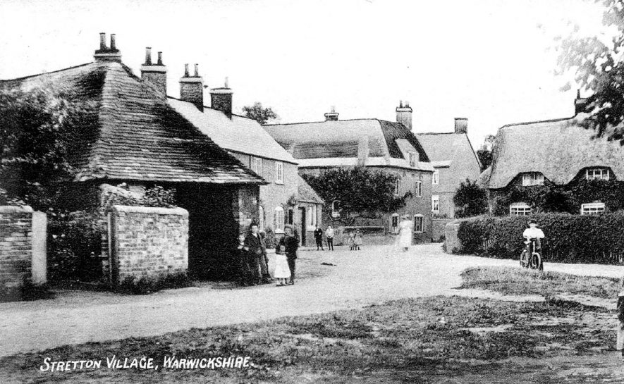 Stretton on Dunsmore street with cottages, one thatched, a three-storey  house, barn,  children and bicycle.  1907 |  IMAGE LOCATION: (Warwickshire County Record Office)