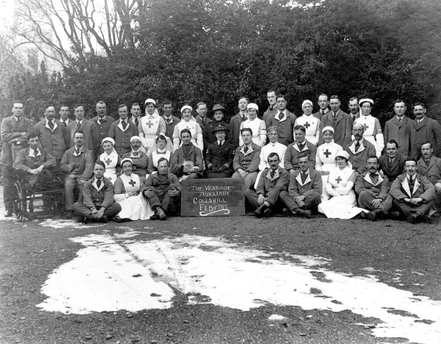 Group photograph of military casualties and nurses with placard: 