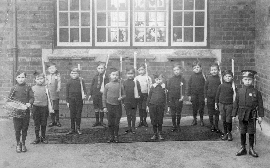 Group of  schoolchildren posing as soldiers outside the public elementary school, Bentley.  1900s |  IMAGE LOCATION: (Atherstone Library)