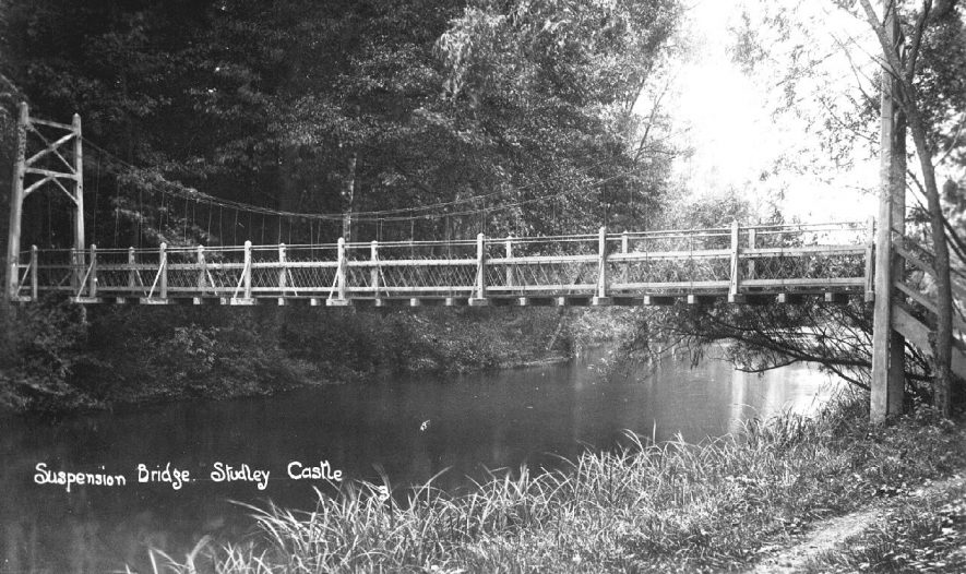 Suspension bridge over a lake at Studley Castle, Studley.  1900s |  IMAGE LOCATION: (Warwickshire County Record Office)