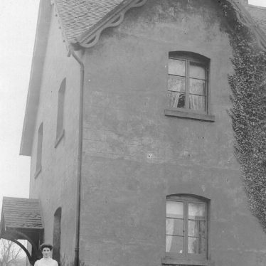 Stockton.  A woman and child outside a house