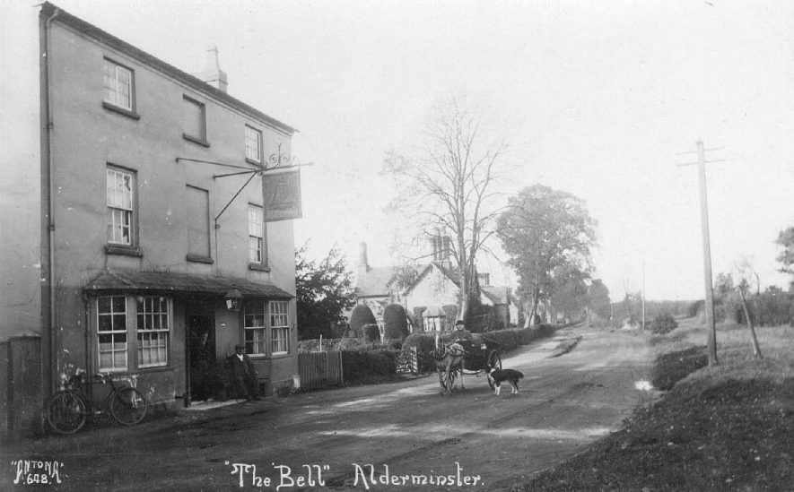 The Bell Inn, Alderminster, with people in doorway, bicycle leaning against wall and pony and trap with man and dog approaching. Houses in background.  1920s |  IMAGE LOCATION: (Warwickshire County Record Office)