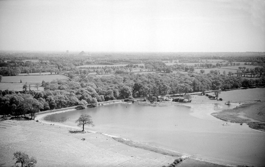 Aerial view of Seeswood Pool with the Nuneaton to Fillongley road in the centre and Newdigate Colliery tip in the distance.  1957 |  IMAGE LOCATION: (Warwickshire County Record Office)