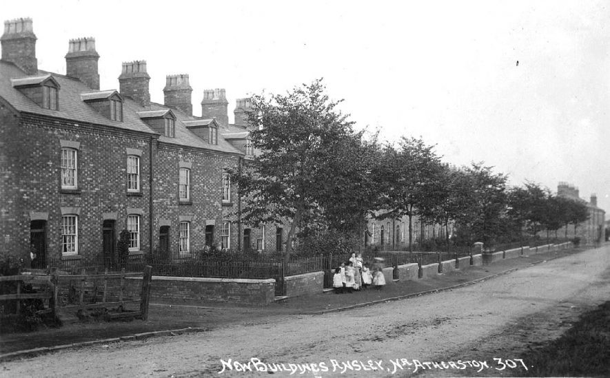 'New Buildings', Beech Terrace, Ansley, showing terraced houses, front gardens and a group of children standing on the pavement.  1910s |  IMAGE LOCATION: (Warwickshire County Record Office)