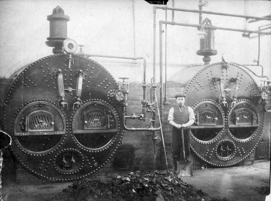 Steam boilers and stoker at Luckman & Pickering's hat making factory in Bedworth.  1910s

[The worker in the picture has been identified as Mr Tommy Lydiatt who was the boilerman. He lived in White Lion Yard, off the Market Place] [It has been suggested that this may not be Tommy Lydiatt, he died in 1898 age 52 and never lived in White Lion Yard but at 286 Bulkington Lane.] |  IMAGE LOCATION: (Warwickshire County Record Office)