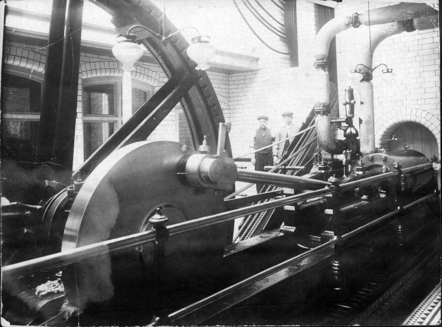 Machinery workshop and two workmen at Luckman & Pickering's hat factory in Bedworth.  1900s |  IMAGE LOCATION: (Warwickshire County Record Office)