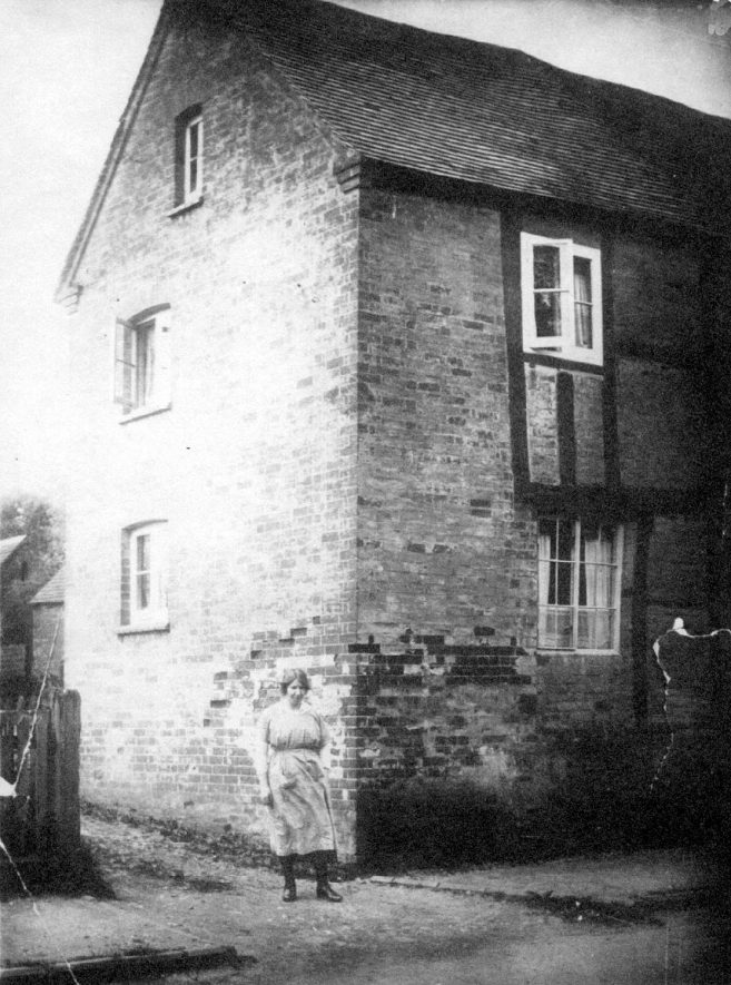 Fidler Bonham's house, with Mrs Bonham standing outside, Bishops Tachbrook.  1920s |  IMAGE LOCATION: (Warwickshire County Record Office) PEOPLE IN PHOTO: Bonham, Mrs