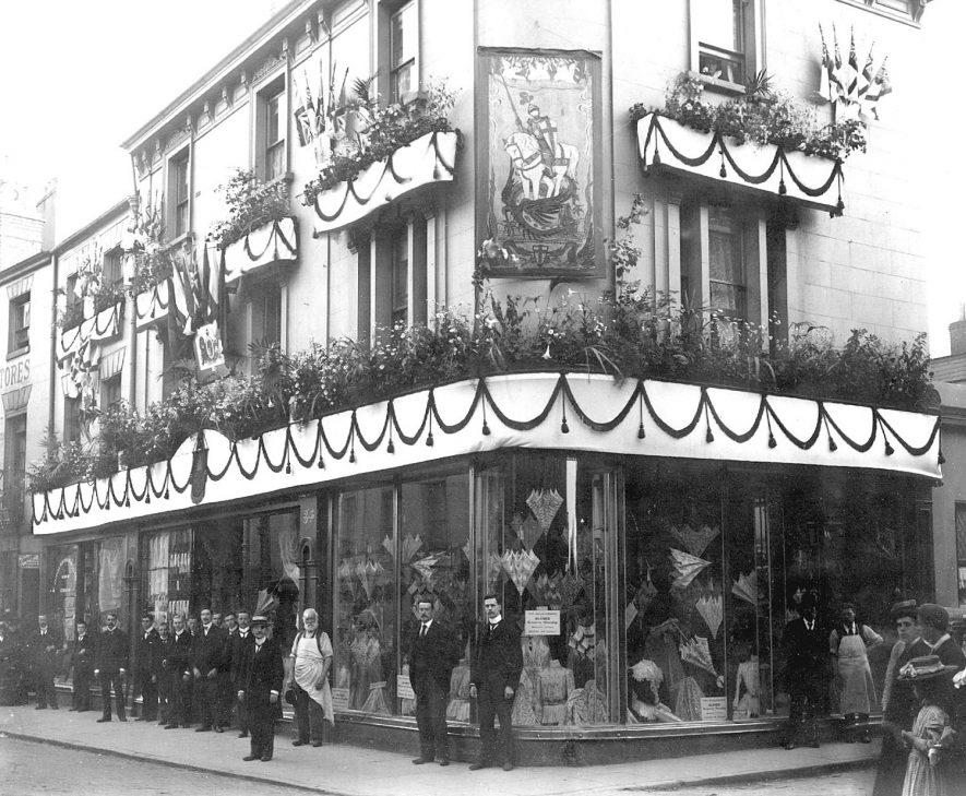 Exterior of E. Francis & Sons Ltd. shop, Bath Street, Leamington Spa  with employees standing in front. The shop is decorated with flags and bunting, possibly to celebrate the coronation of King George V.  1910s |  IMAGE LOCATION: (Warwickshire Museums. Photographic Collections.)