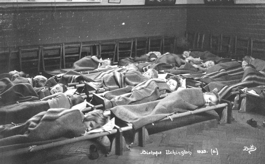 Group of children resting on camp beds at Bishops Itchington school.  1933 |  IMAGE LOCATION: (Warwickshire County Record Office)