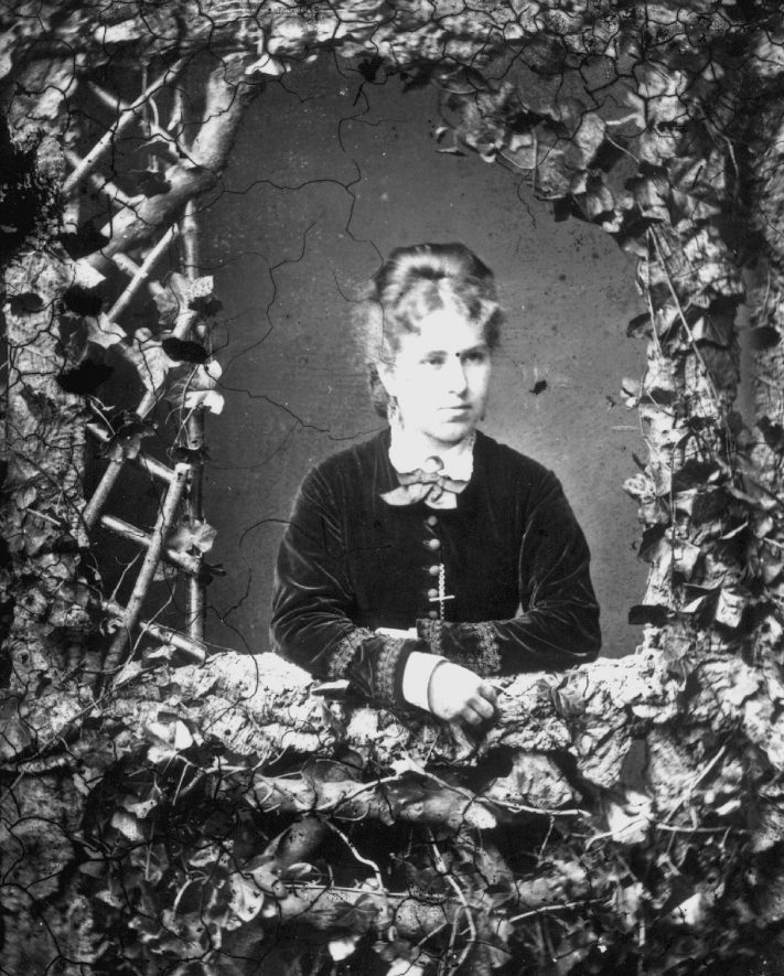 Portrait of a woman with the surname Watson posed behind a rustic trellis photographers set.  1874 |  IMAGE LOCATION: (Warwickshire County Record Office) PEOPLE IN PHOTO: Watson as a surname