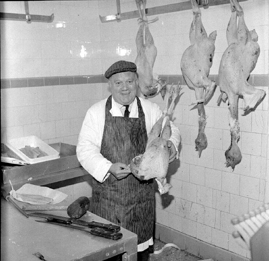 George Jarman holding a Christmas turkey in J.O. Lea's poultry and fishmongers shop, Abbey Street, Nuneaton.  December 17th 1968 |  IMAGE LOCATION: (Warwickshire County Record Office) PEOPLE IN PHOTO: Jarman, George