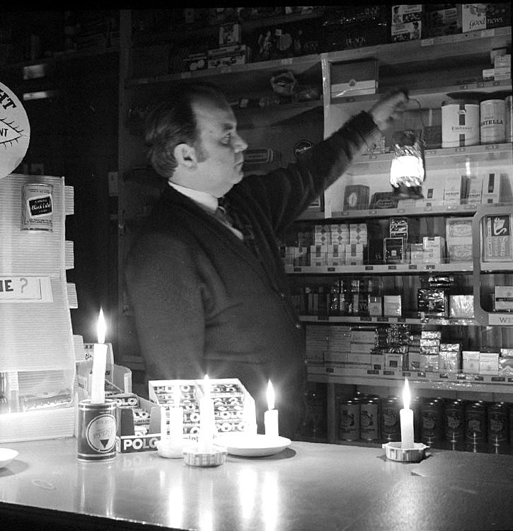 Mr Francis Reynolds working by candlelight in his off-licence in Queens Street, Nuneaton, during the miner's strike.  March 1st 1972 |  IMAGE LOCATION: (Warwickshire County Record Office) PEOPLE IN PHOTO: Reynolds, Francis, Reynolds as a surname