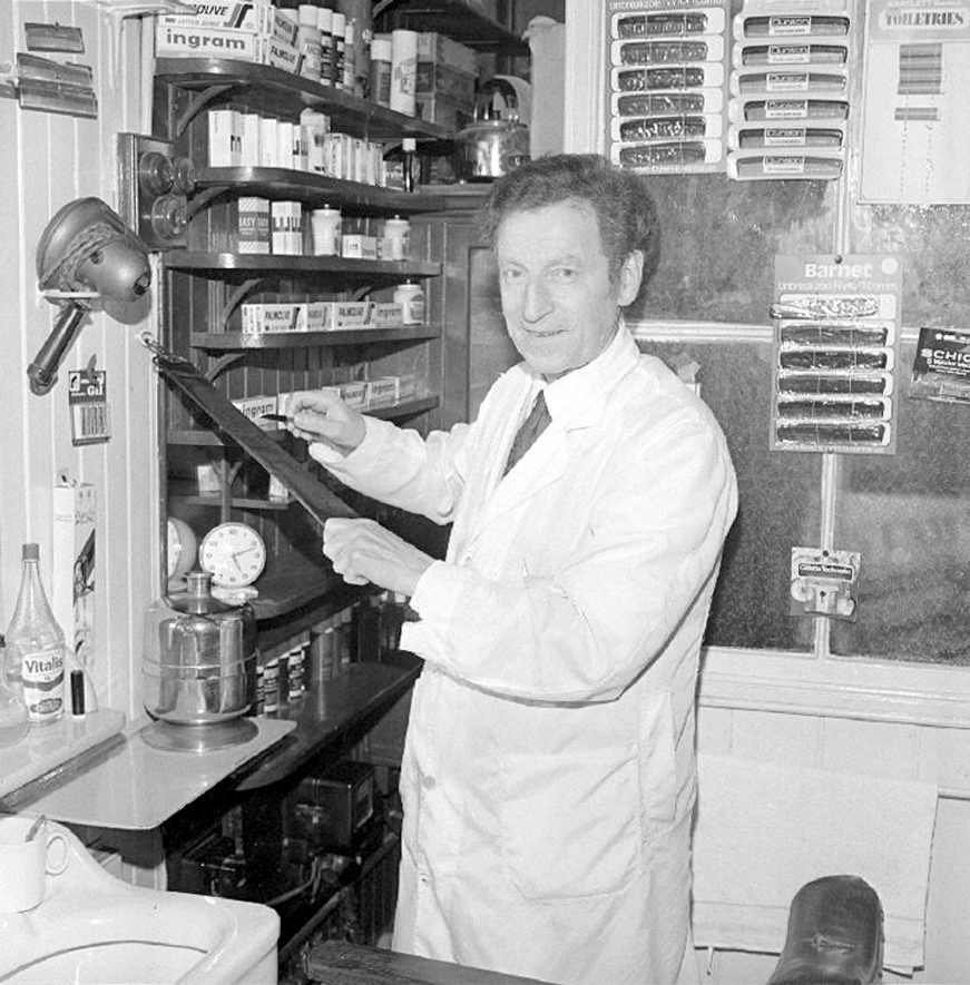 John Mugglestone sharpening a razor in his barbers shop in Abbey Street, Nuneaton.  November 13th 1974 |  IMAGE LOCATION: (Warwickshire County Record Office) PEOPLE IN PHOTO: Mugglestone, John, Mugglestone as a surname