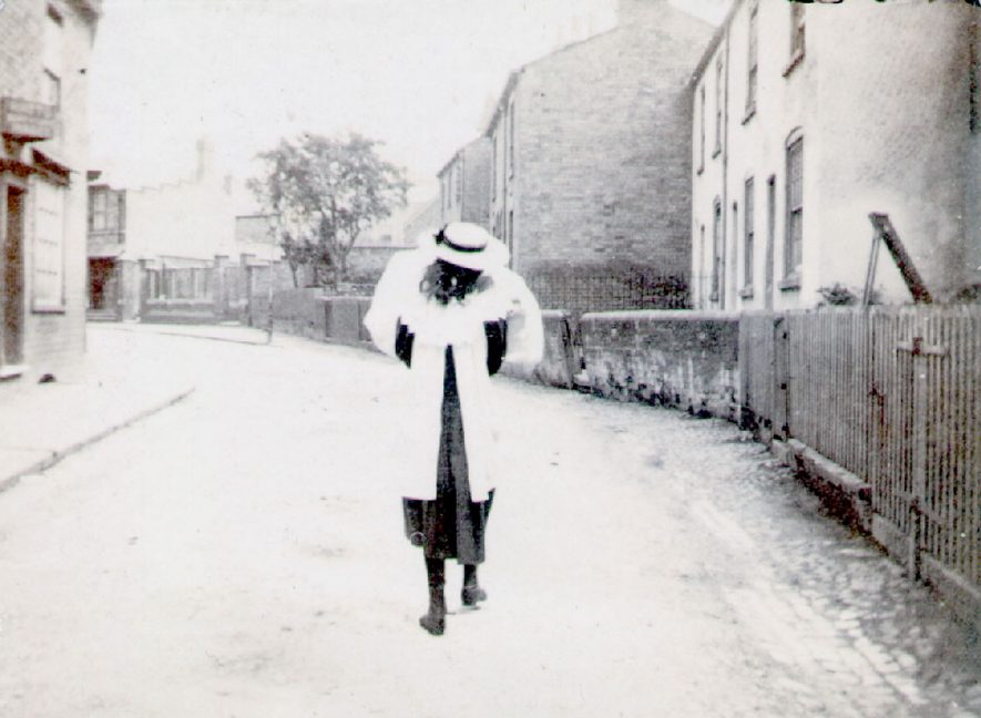 A young girl walking along Chapel Street, Rugby.  1900 |  IMAGE LOCATION: (Rugby Library)
