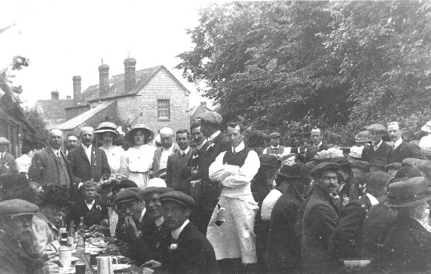 Group of people sitting round trestle tables at the coronation in 1911. |  IMAGE LOCATION: (Warwickshire County Record Office)