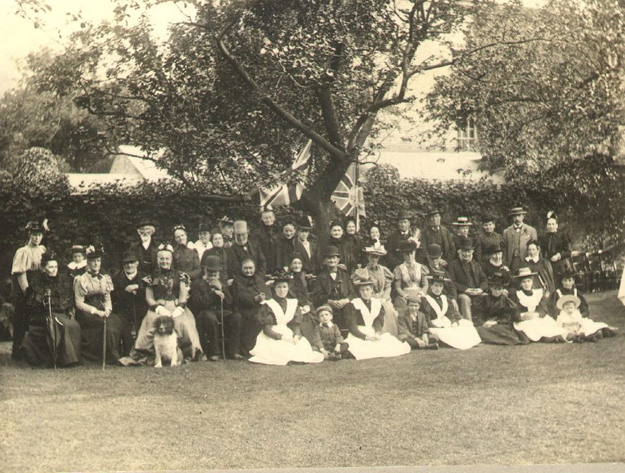 A group taken in the garden at Burford House, Rugby during Queen Victoria's Diamond Jubilee celebrations. On the left is Mrs Morgan Molesworth, Miss Winstanley (with dog), Mr Morris. On the extreme right is Mr A.E. Treen and his mother.  June 1897 |  IMAGE LOCATION: (Rugby Library) PEOPLE IN PHOTO: Winstanley, Miss, Winstanley as a surname, Treen, Mr A E, Treen as a surname, Morris, Mr, Morris as a surname, Molesworth, Mrs Morgan, Molesworth as a surname