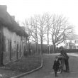 Monks Kirby.  Man and child standing in the road