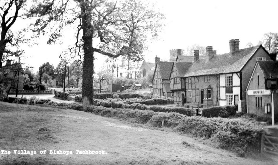 Scene of part of Bishops Tachbrook village showing timber framed cottages with church in the background.  1950s |  IMAGE LOCATION: (Warwickshire County Record Office)